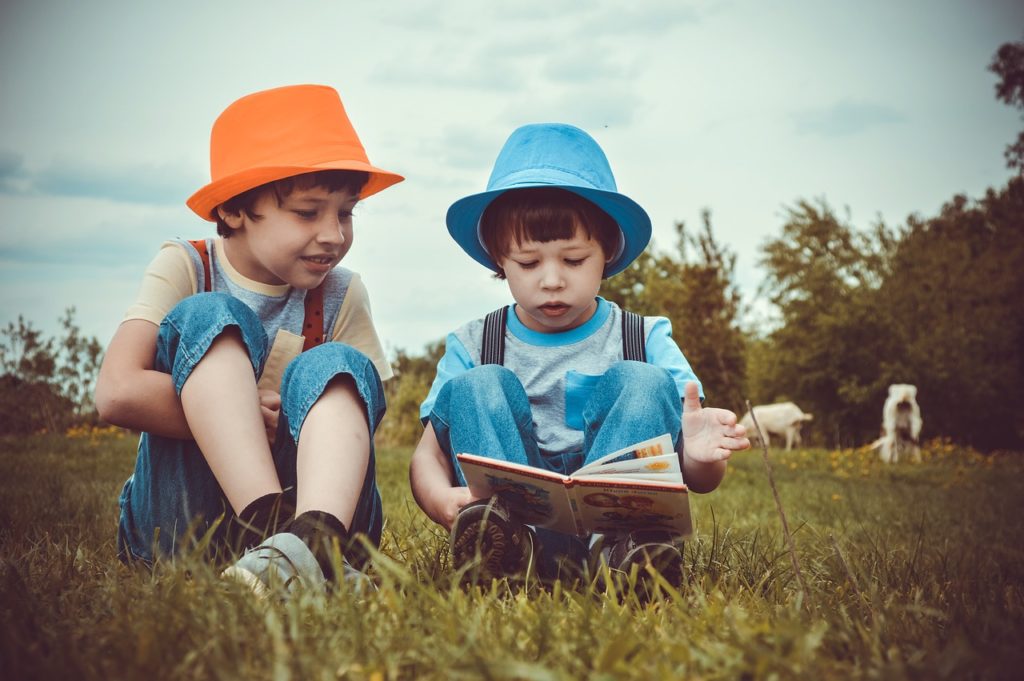 Two boys reading outdoors
